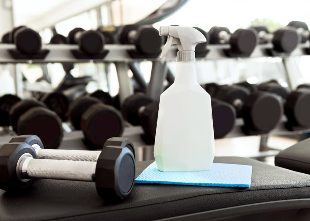 spray botle right next to a dumbbell