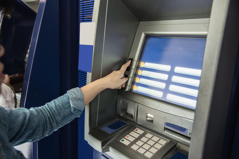 People waiting to get money from automated teller machine - people withdrawn money from ATM concept